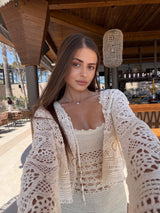 Woman wearing a beige crochet outfit in an outdoor setting